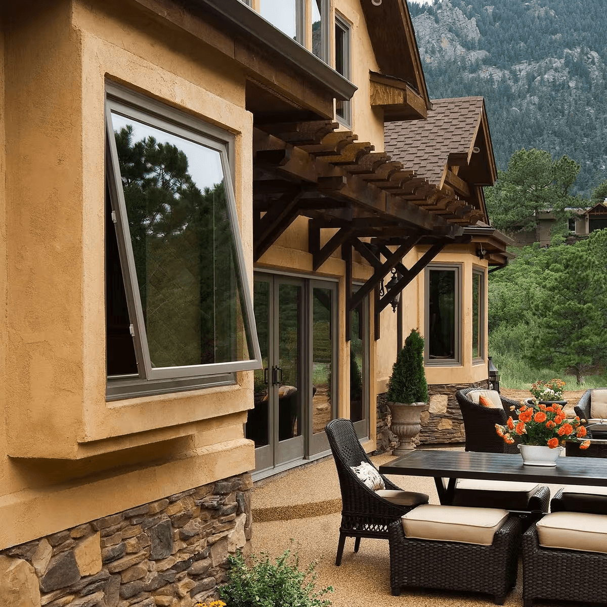 Open awning window on a stucco home overlooking a mountain patio