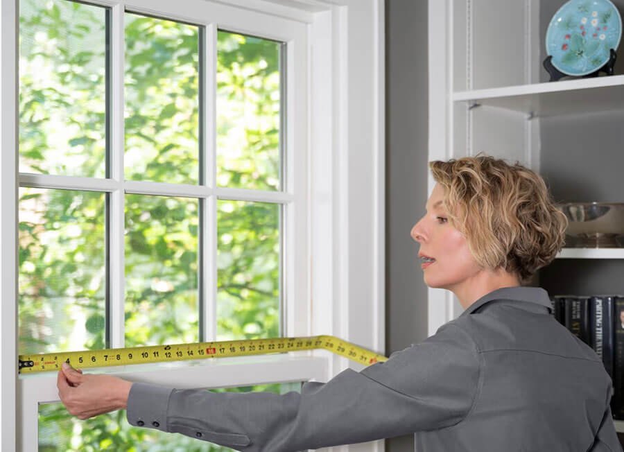 Project technician measuring a window opening
